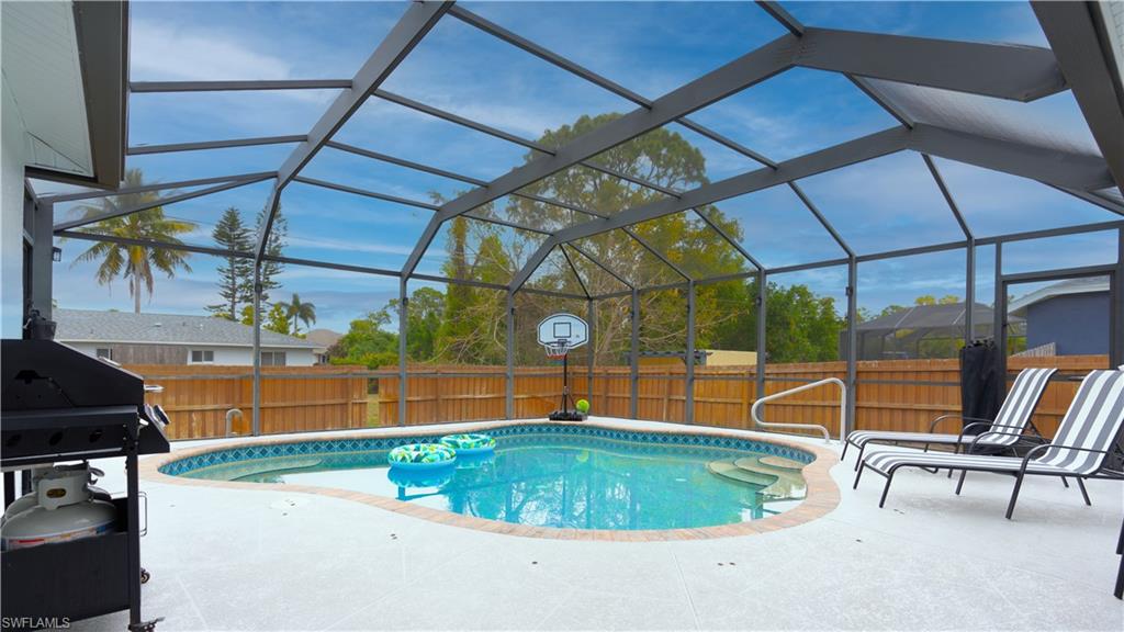 9151 Irving Road Fort Myers, FL 33967 - Photo 6 of 44 View of pool with area for grilling, a lanai, a fenced backyard, and a sunroom
