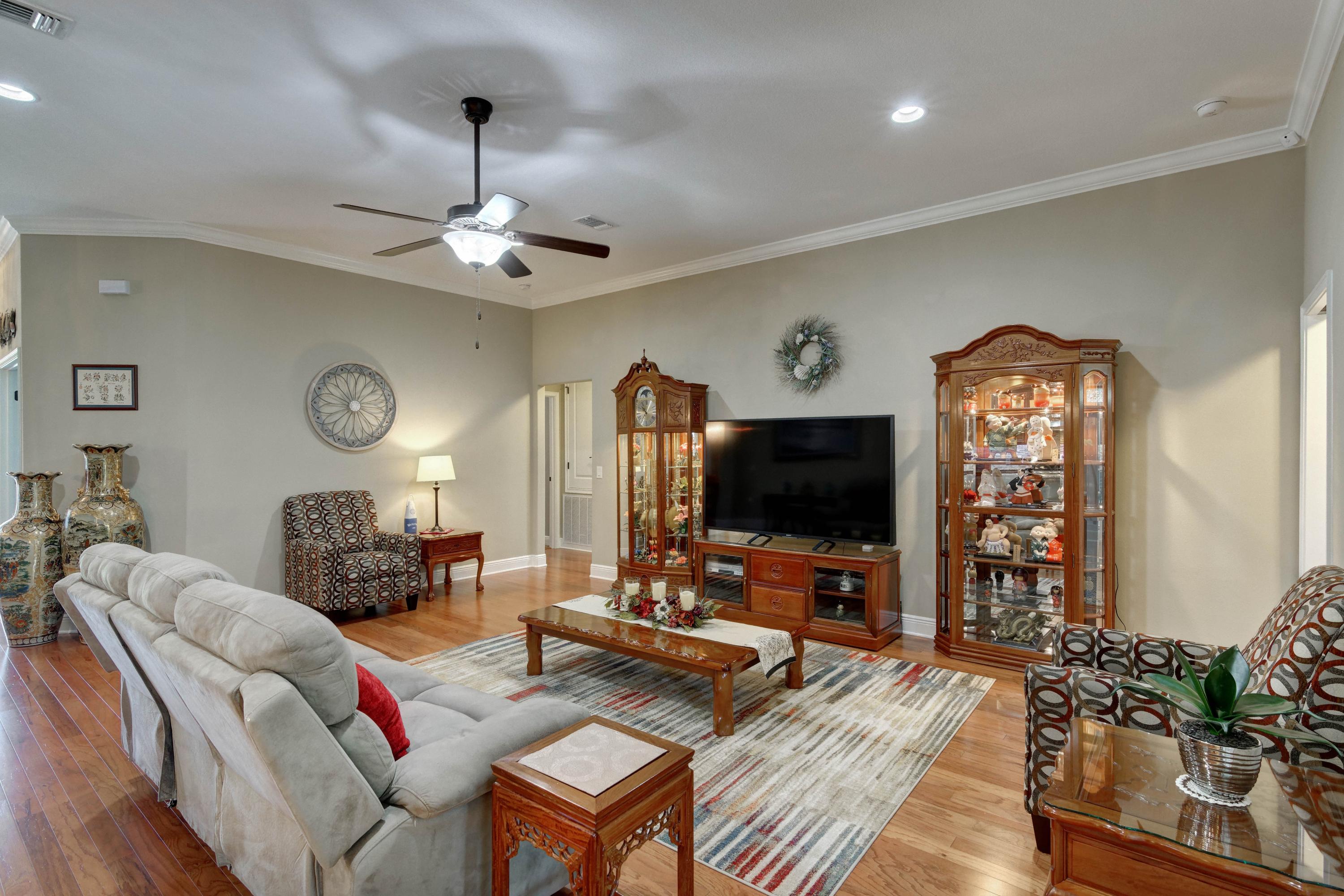 2592 Crescent Road Navarre, FL 32566 - Photo 14 of 67 a living room with furniture a chandelier and a flat screen tv
