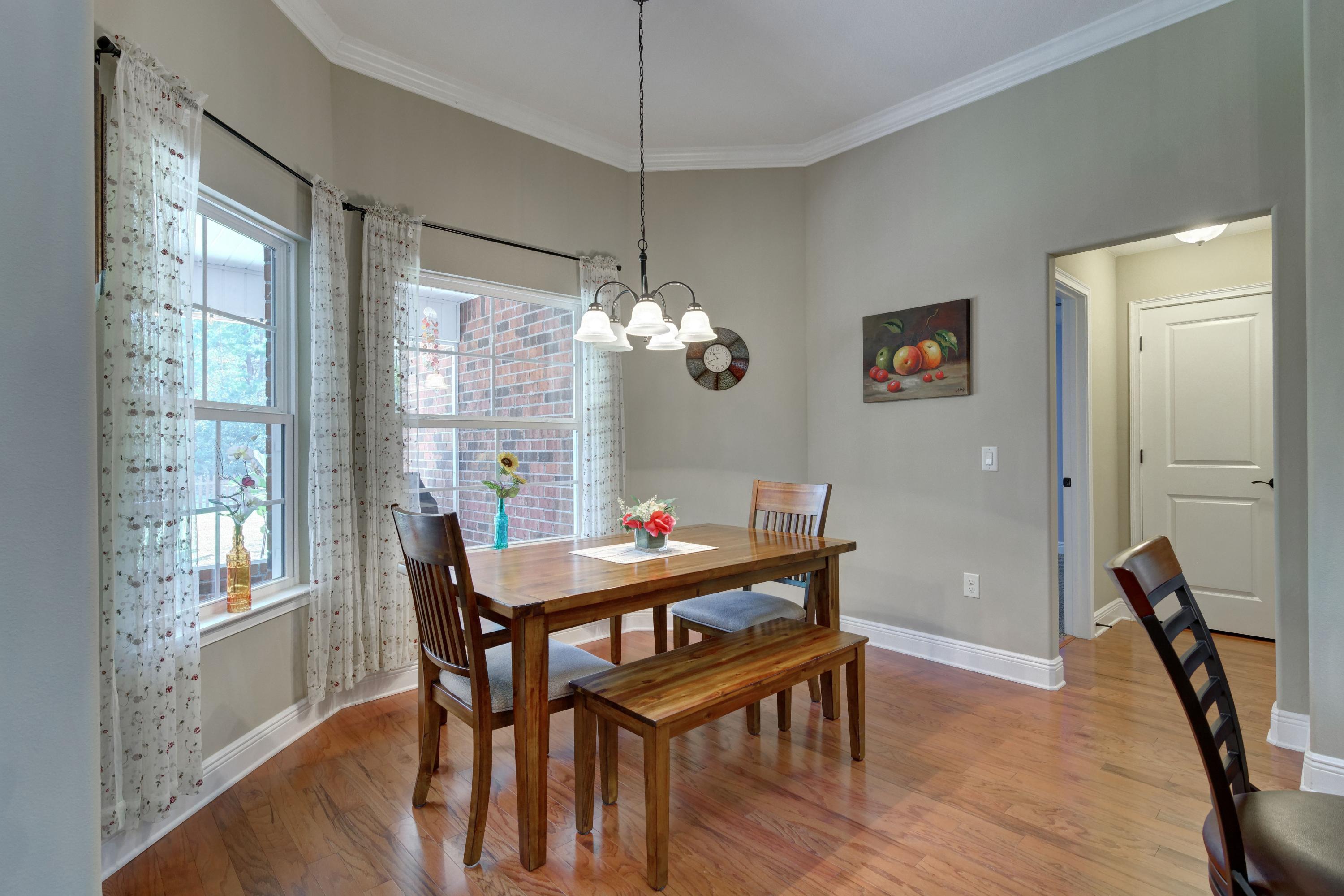 2592 Crescent Road Navarre, FL 32566 - Photo 15 of 67 a dining room with furniture a chandelier and wooden floor