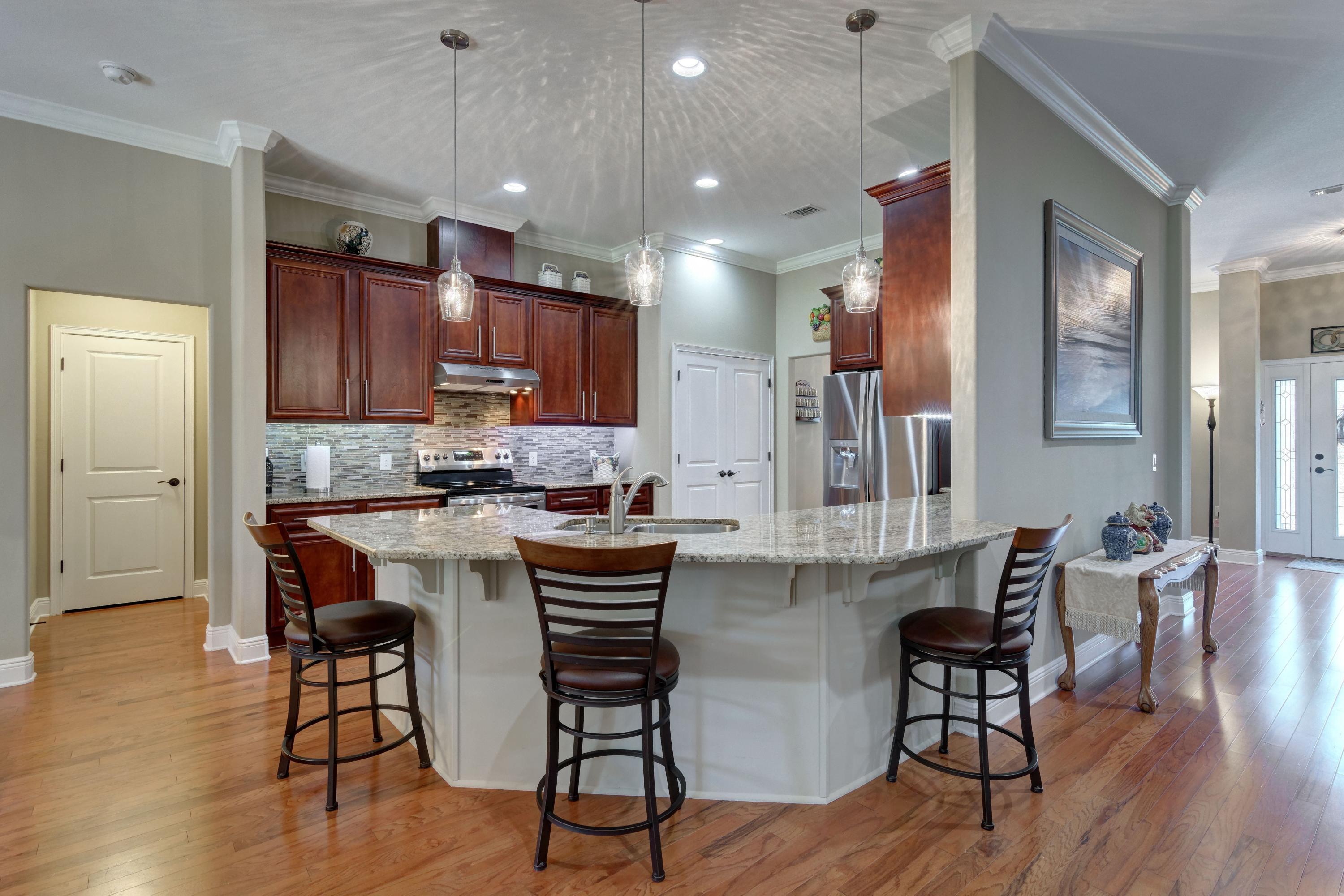 2592 Crescent Road Navarre, FL 32566 - Photo 17 of 67 a kitchen with stainless steel appliances kitchen island granite countertop a table chairs and a refrigerator