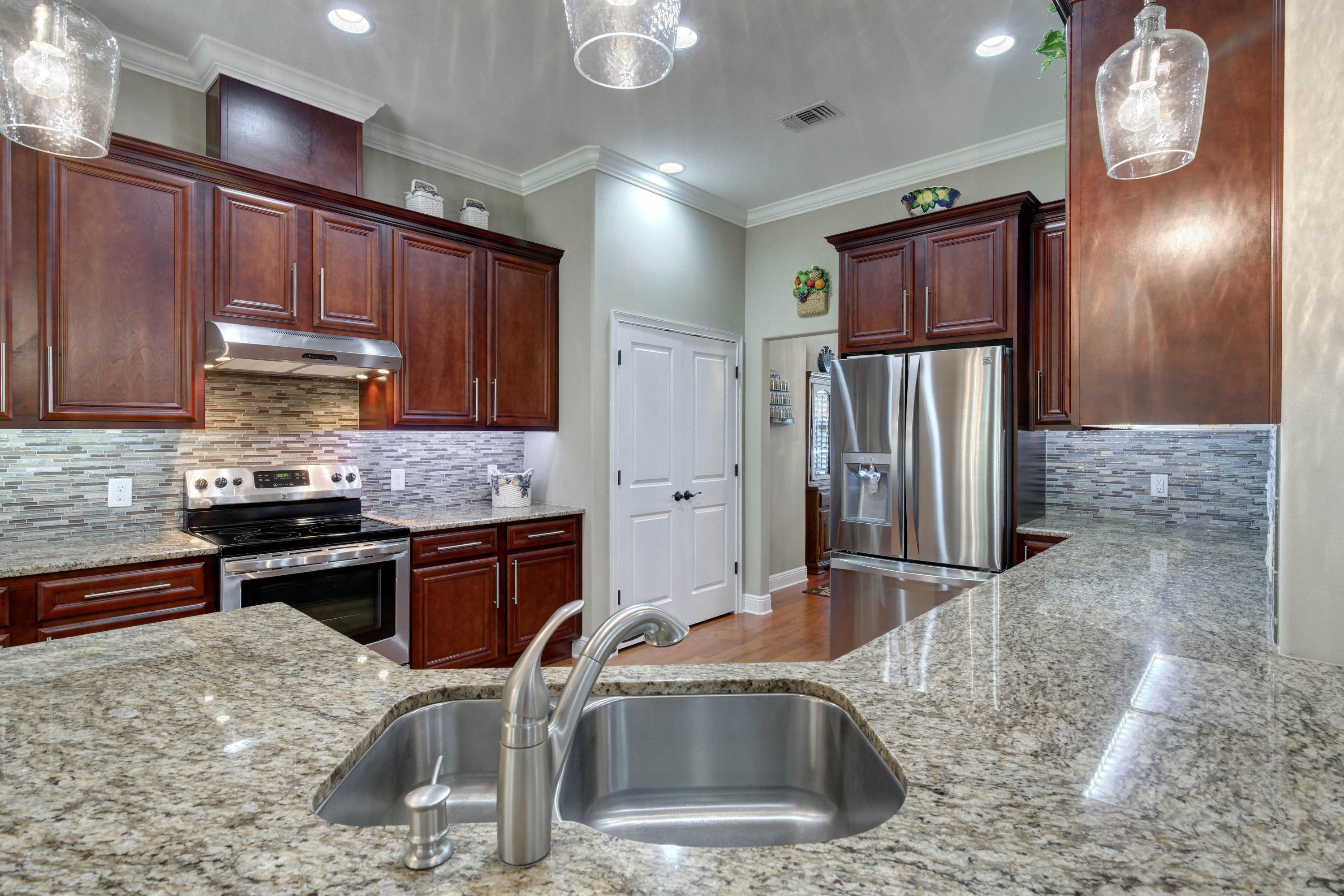 2592 Crescent Road Navarre, FL 32566 - Photo 19 of 67 a kitchen with stainless steel appliances granite countertop a sink refrigerator and cabinets