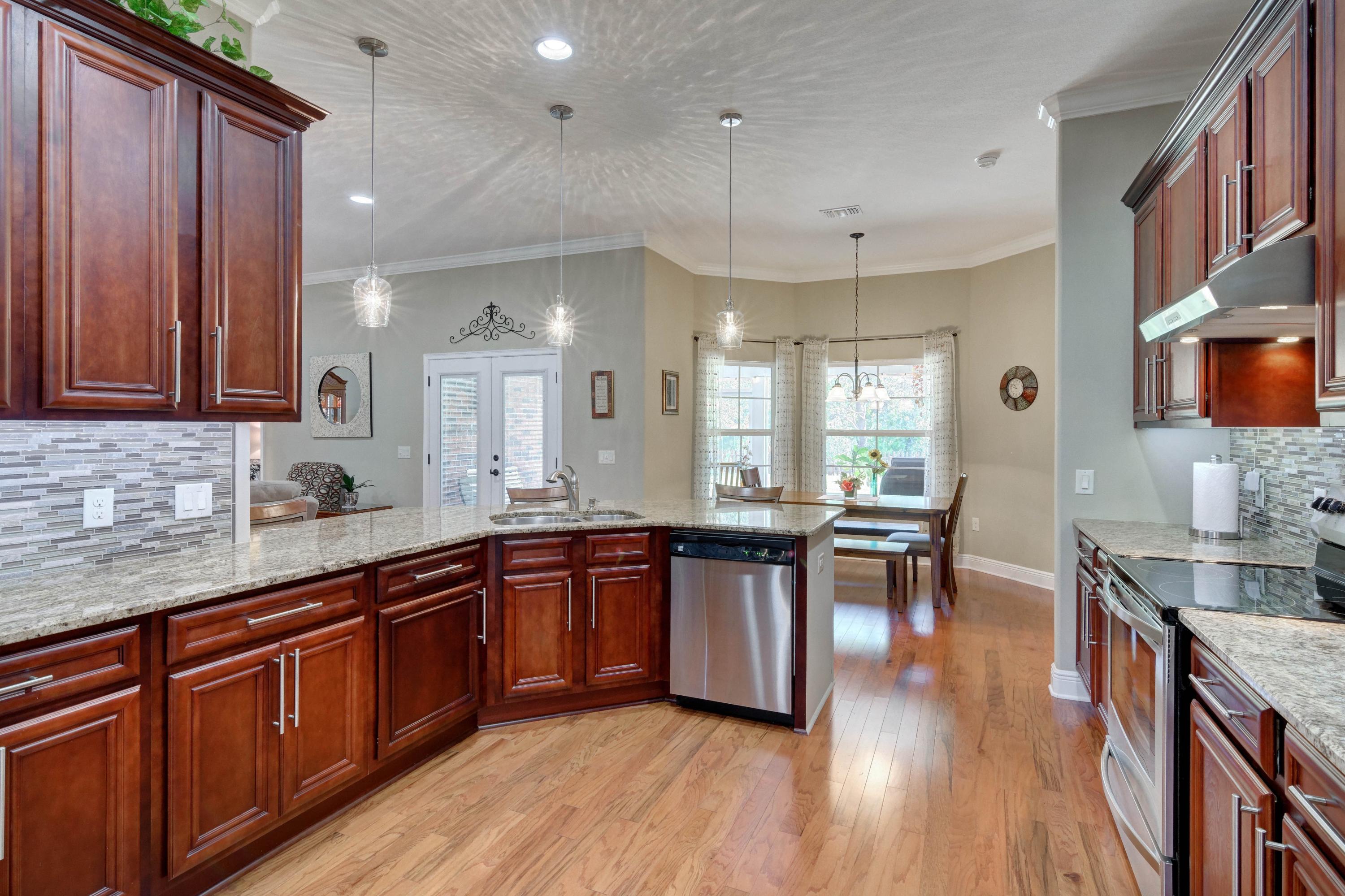 2592 Crescent Road Navarre, FL 32566 - Photo 22 of 67 a large kitchen with cabinets chairs and wooden floor
