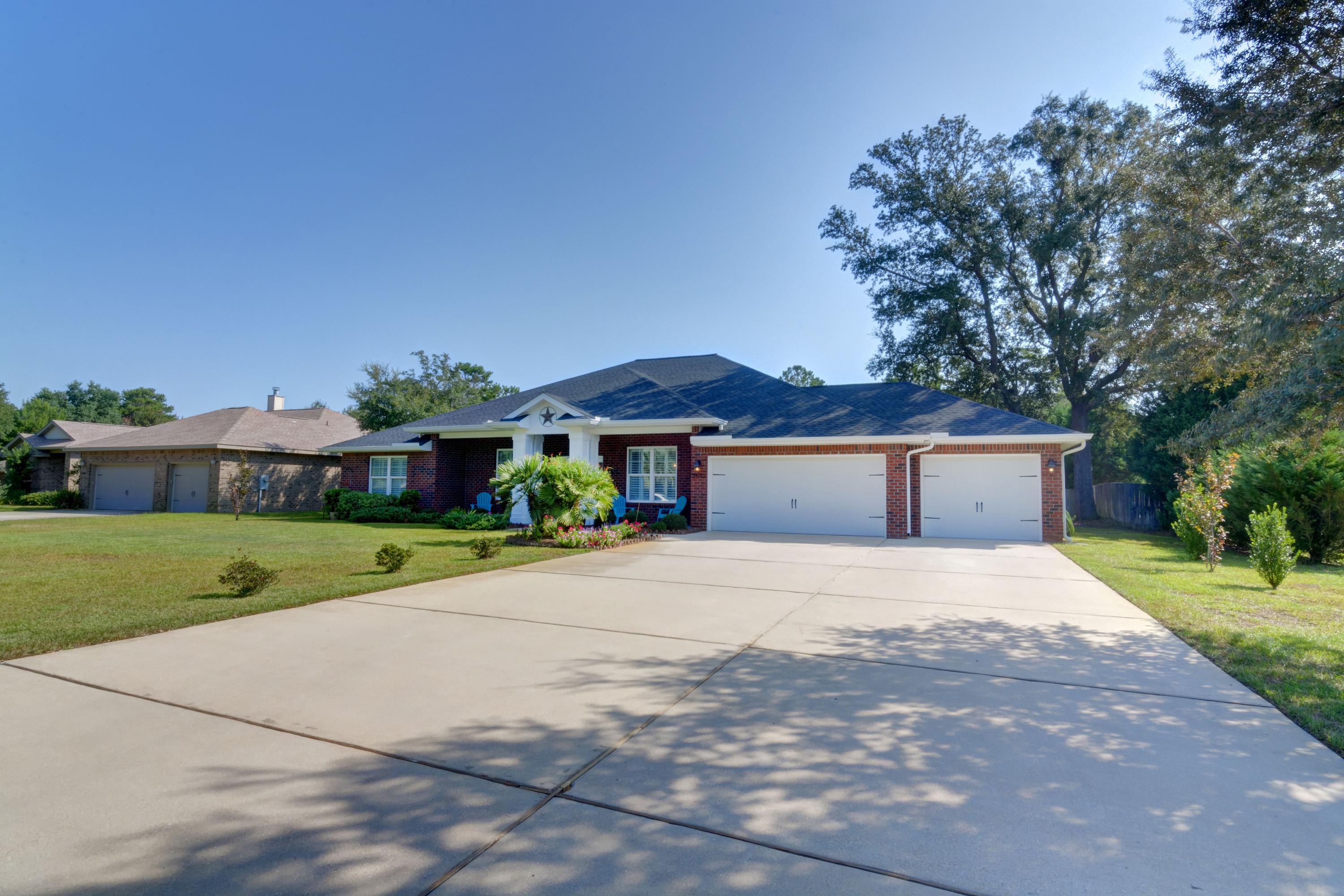 2592 Crescent Road Navarre, FL 32566 - Photo 58 of 67 a front view of a house with a yard and garage