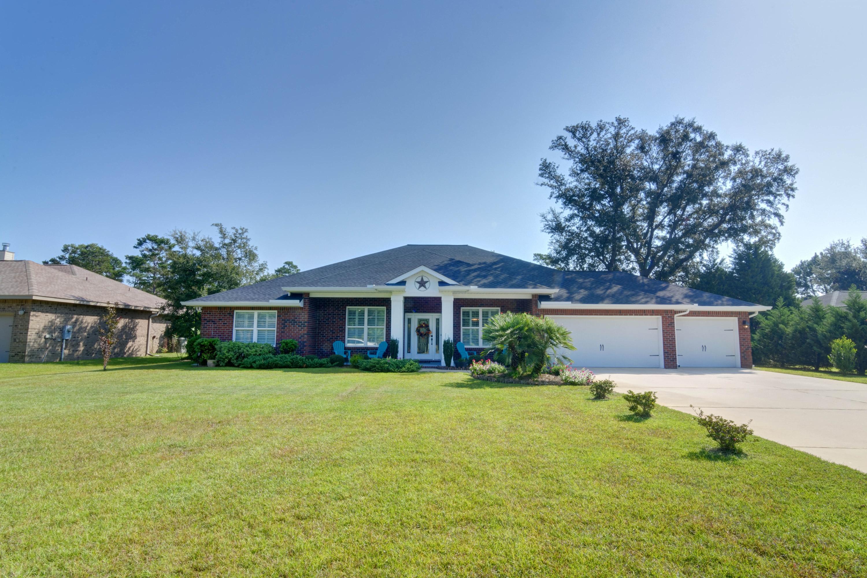 2592 Crescent Road Navarre, FL 32566 - Photo 59 of 67 a front view of a house with a yard and trees