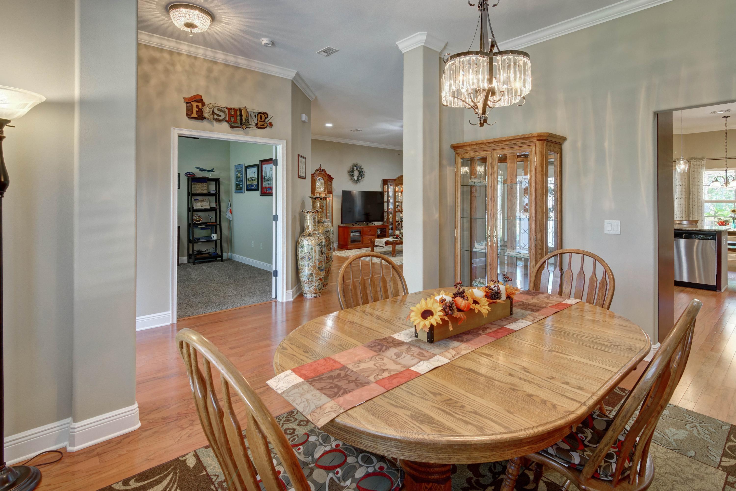 2592 Crescent Road Navarre, FL 32566 - Photo 9 of 67 a dining room with furniture a chandelier and wooden floor
