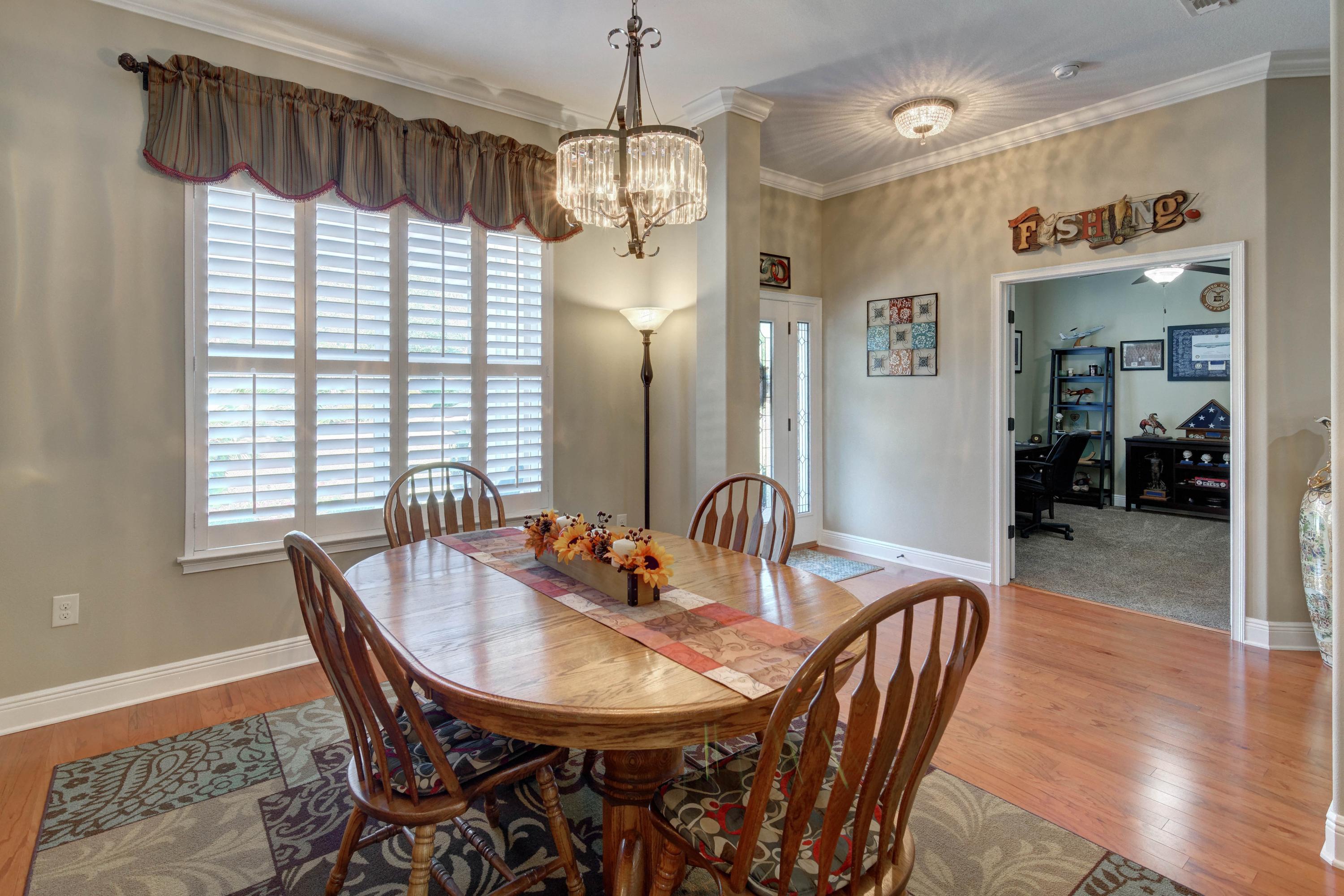 2592 Crescent Road Navarre, FL 32566 - Photo 10 of 67 a dining room with furniture a chandelier and wooden floor