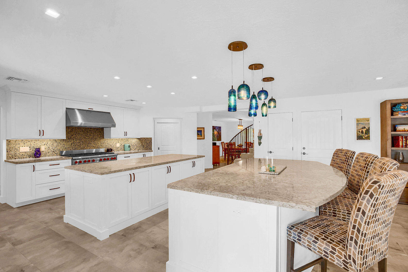 153 Key Haven Road Key West, FL 33040 - Photo 16 of 28 a kitchen with stainless steel appliances granite countertop a stove a sink a microwave a dining table and chairs with wooden floor