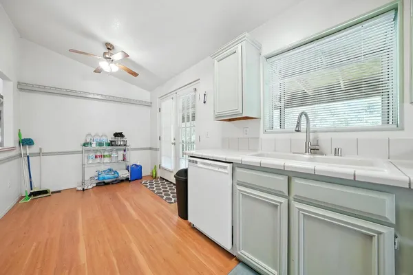 a view of a wooden house with a small yard and wooden fence