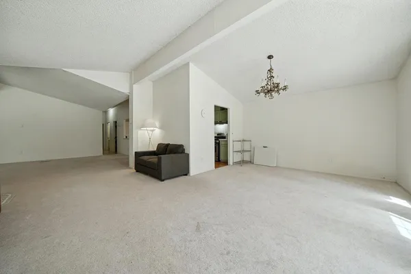 a view of a livingroom with a fireplace a chandelier and windows