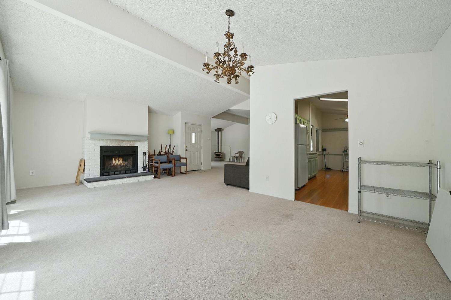 16000 Sutter Creek Road Sutter Creek, CA 95685 - Photo 6 of 80 a view of a livingroom with a fireplace a chandelier and windows