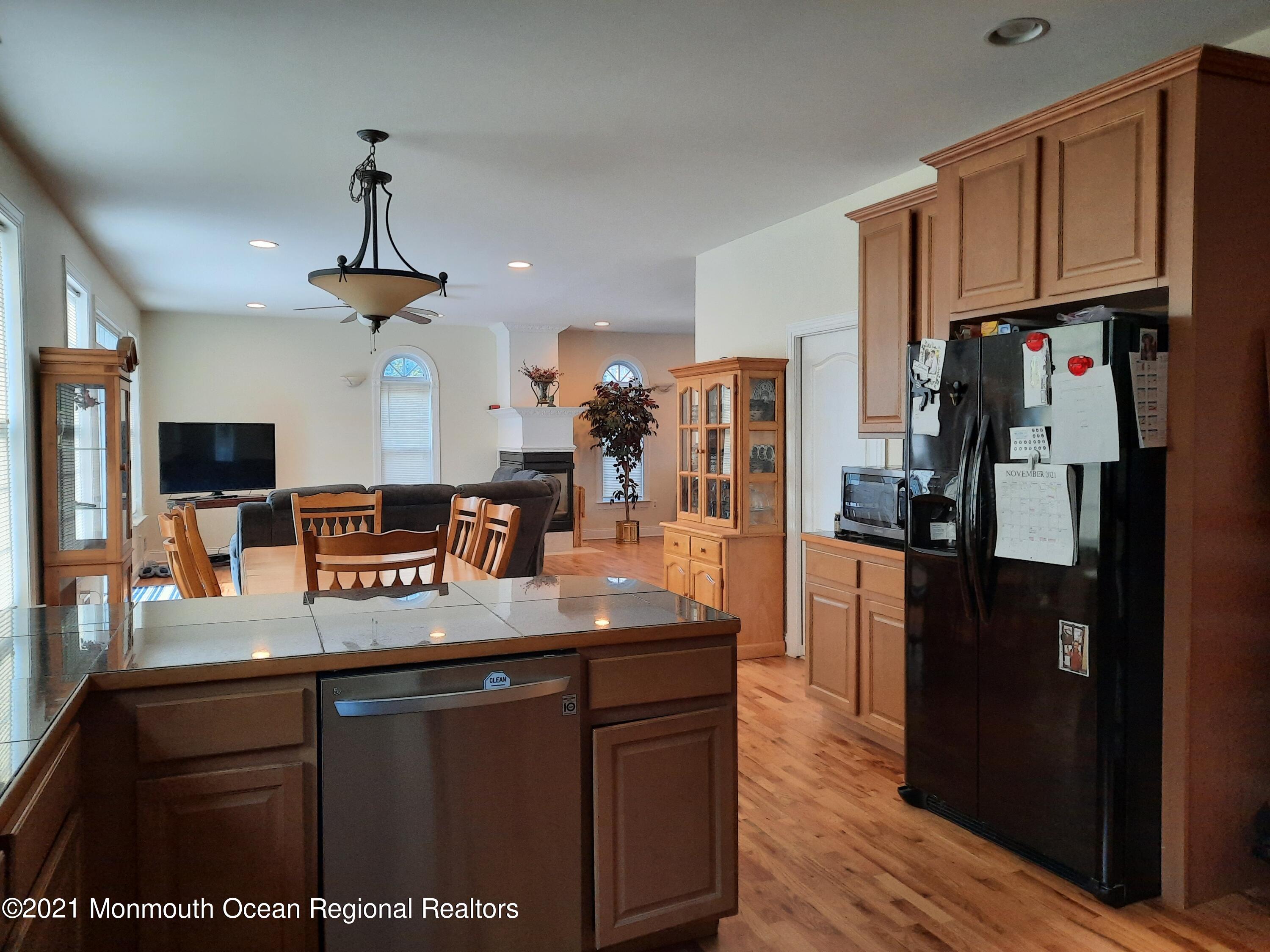 607 Dave Marion Road Toms River, NJ 08753 - Photo 8 of 9 a kitchen with stainless steel appliances granite countertop a refrigerator a sink dishwasher and wooden cabinets with wooden floor
