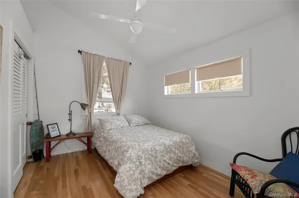a bedroom with a bed a dresser with wooden floor