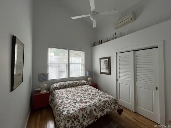 a bedroom with a bed wooden floor and window