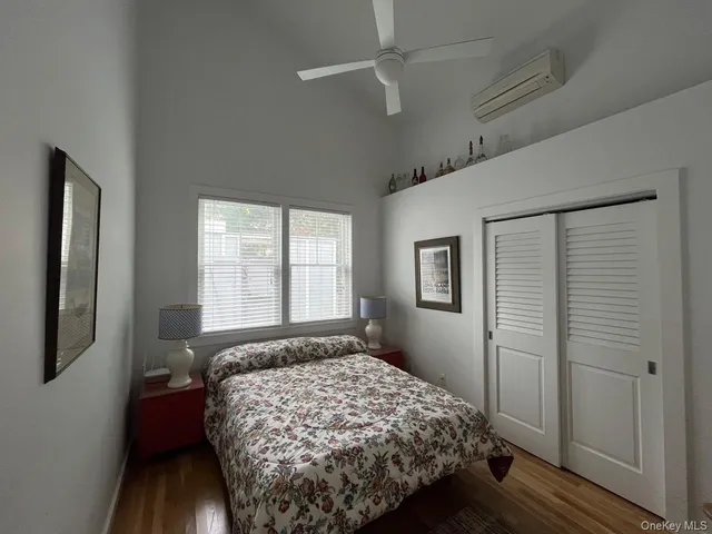 a bedroom with a bed wooden floor and window