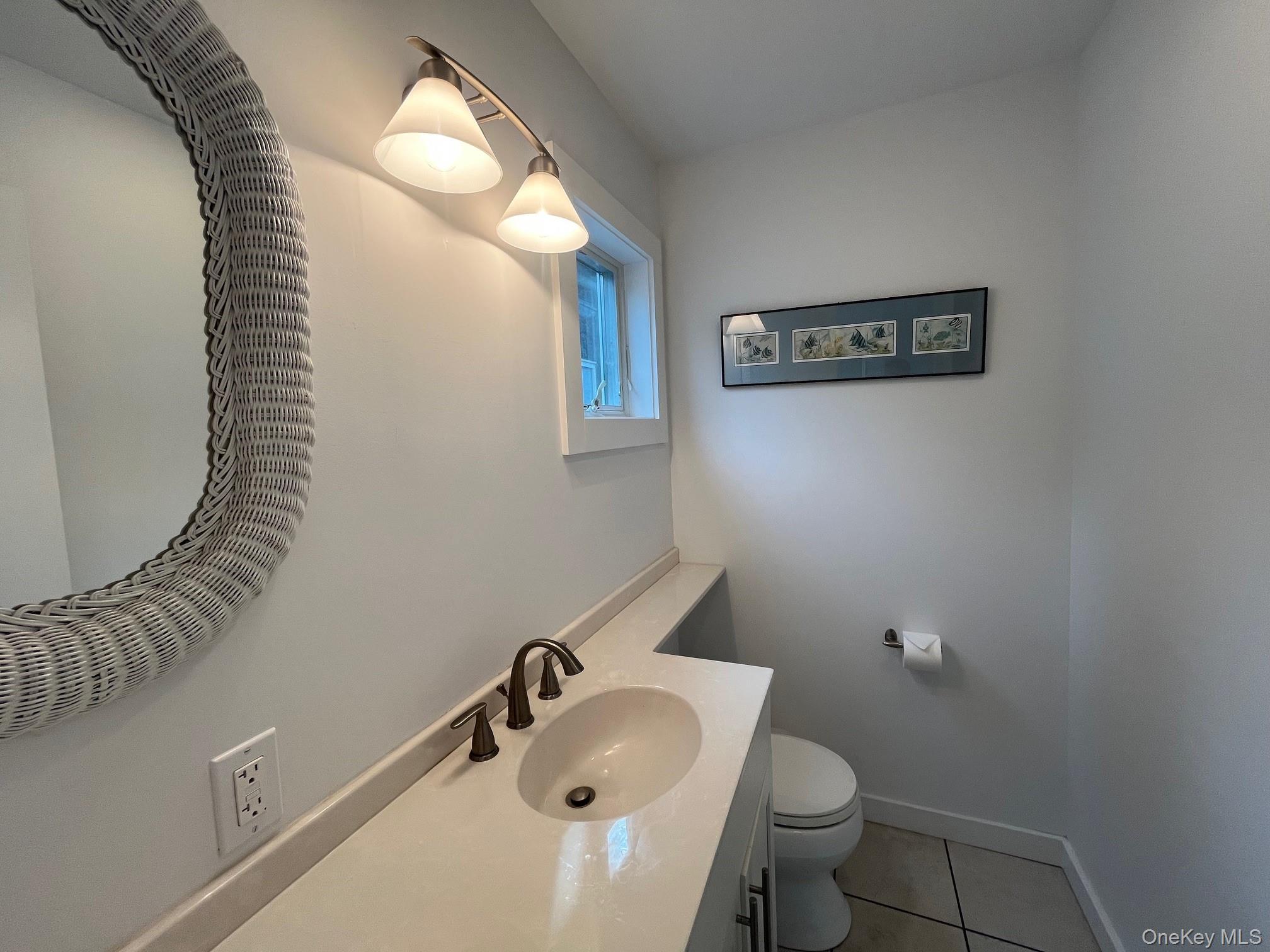 55 Ocean Road Ocean Beach, NY 11770 - Photo 13 of 14 a bathroom with a toilet sink and mirror