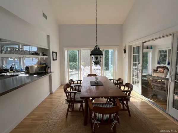 a view of a dining room and livingroom with furniture wooden floor a chandelier