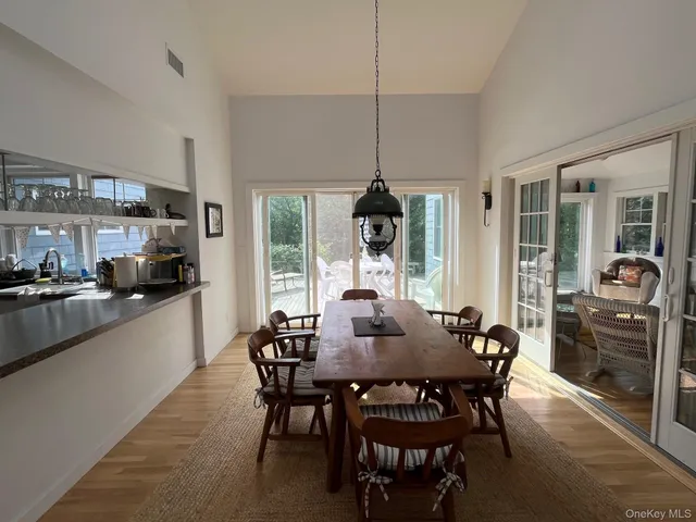 a view of a dining room and livingroom with furniture wooden floor a chandelier