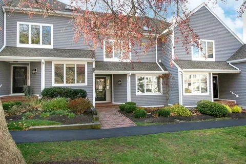 front view of a brick house with a yard