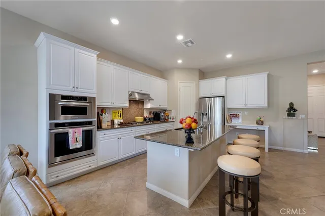 a kitchen with stainless steel appliances a refrigerator and a stove top oven