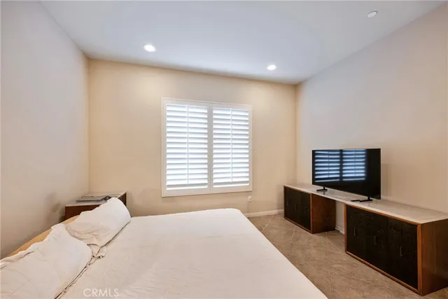a view of a swimming pool with lawn chairs under palm trees