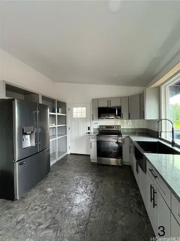 a kitchen with granite countertop a stove top oven and cabinets