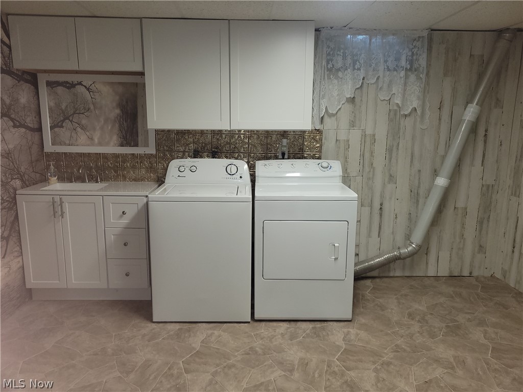 9692 Hess Mill Road Northeast Bolivar, OH 44612 - Photo 21 of 33 Laundry area with cabinets, washing machine and clothes dryer, sink, and light tile patterned floors