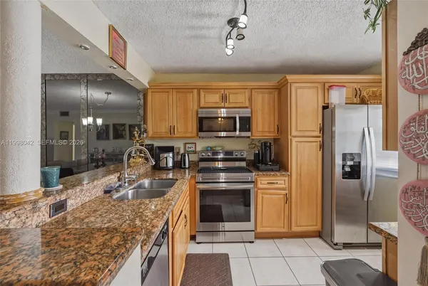 a kitchen with stainless steel appliances granite countertop a stove refrigerator and microwave