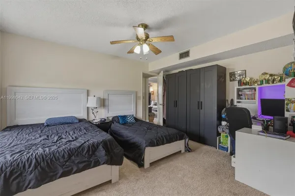 a bedroom with a bed and a ceiling fan