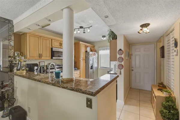 a kitchen with stainless steel appliances granite countertop a sink and a refrigerator