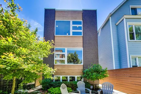 a view of a house with potted plants and a tree