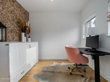 a view of a workspace with furniture and a window