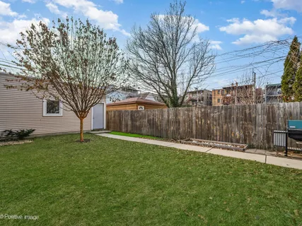 a backyard with wooden fence and large trees