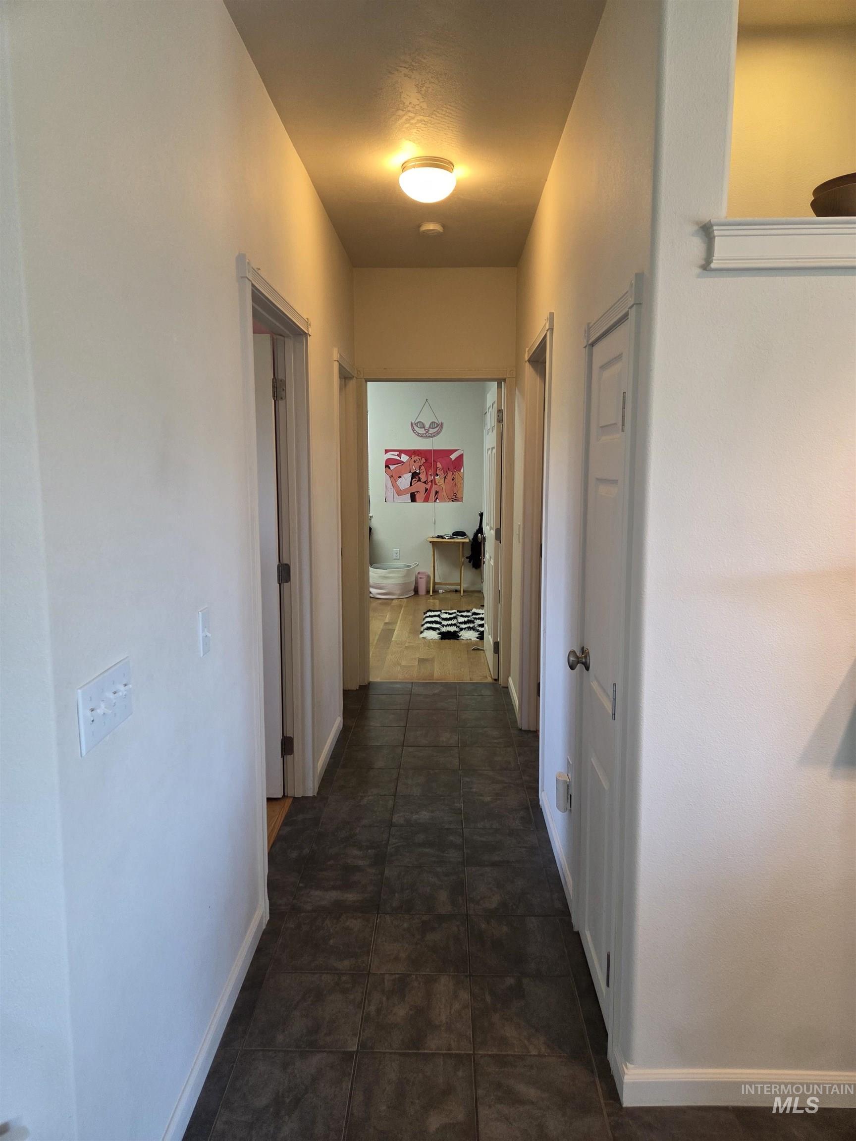 1085 Wallen Road Moscow, ID 83843 - Photo 19 of 50 Hallway featuring dark tile flooring, white baseboards, and white trim around doorways