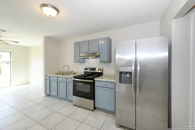 a kitchen with stainless steel appliances granite countertop a refrigerator and a sink