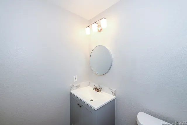 a bathroom with a sink mirror and toilet