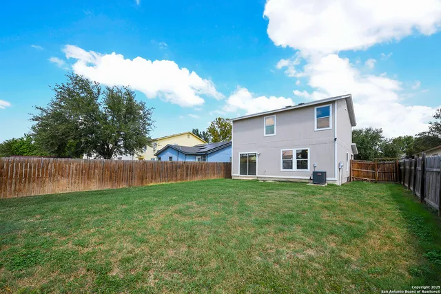a view of a house with a yard and fence