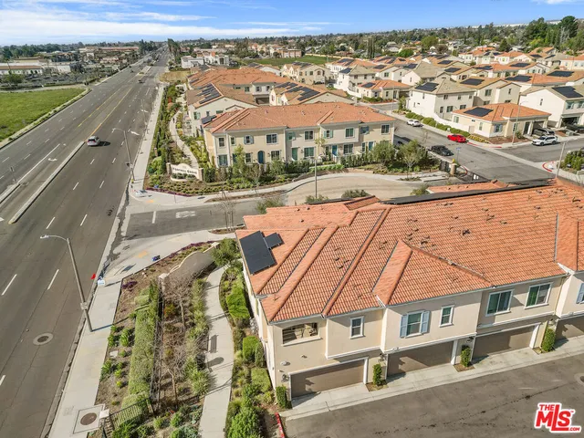 an aerial view of residential houses with outdoor space and ocean view