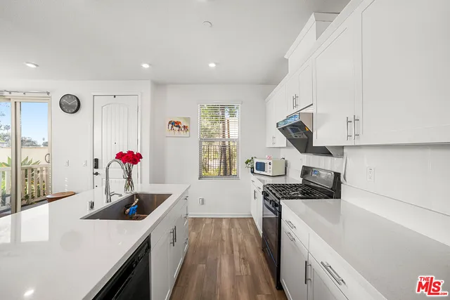 a kitchen with granite countertop a sink stove and cabinets