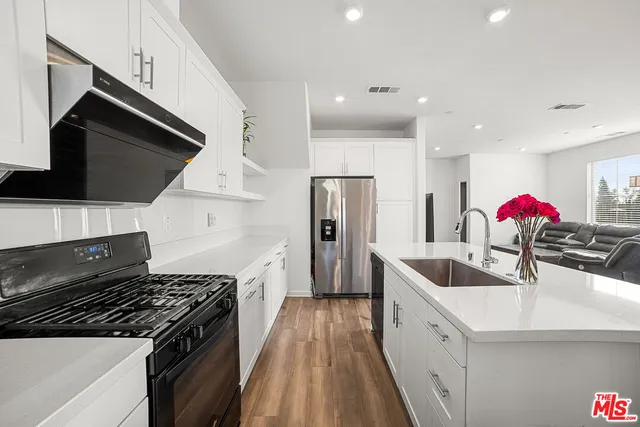a kitchen with granite countertop a sink and a stove top oven