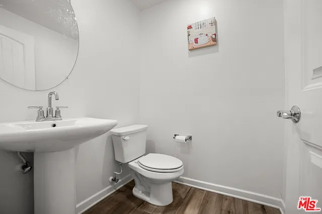a bathroom with a toilet a sink and mirror