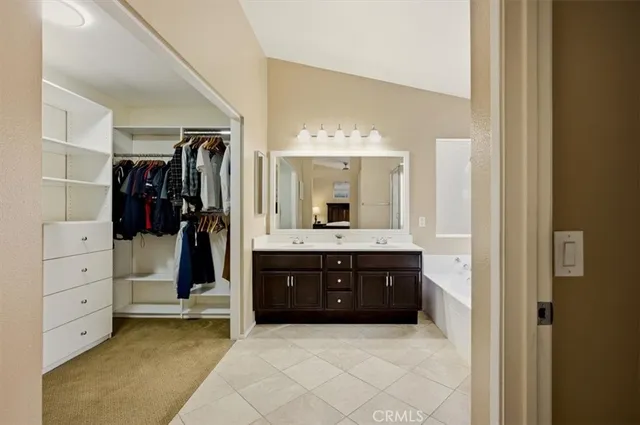 a spacious bathroom with a double vanity sink a mirror and a bathtub