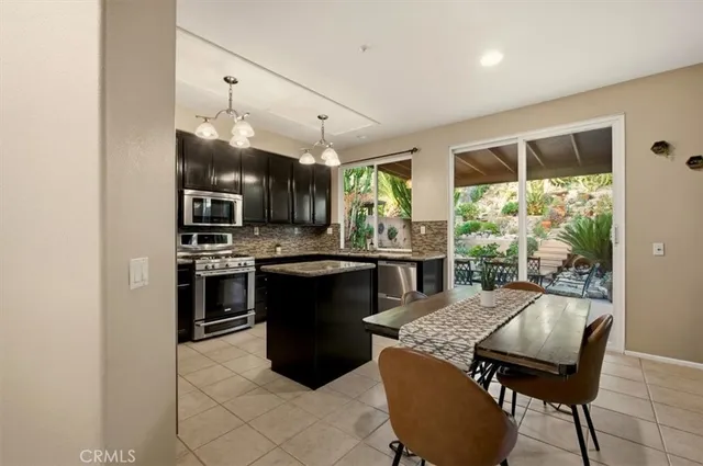 a kitchen with a table chairs refrigerator and cabinets
