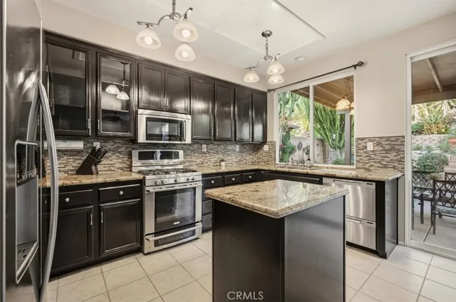 a kitchen with granite countertop stainless steel appliances a stove sink and microwave