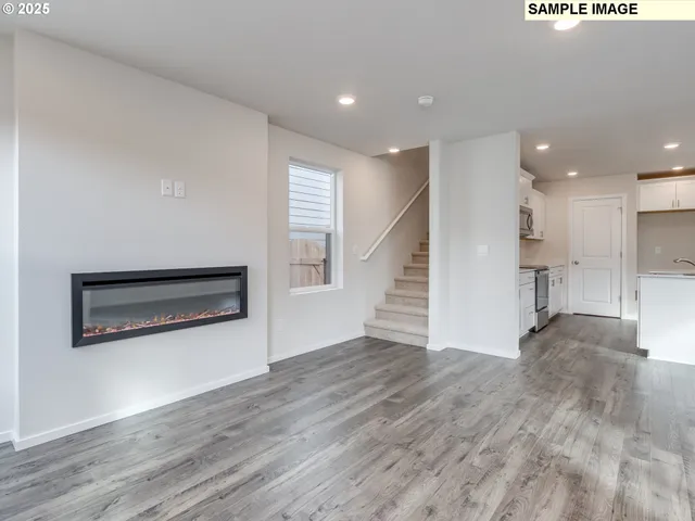 a view of a hallway with wooden floor and kitchen