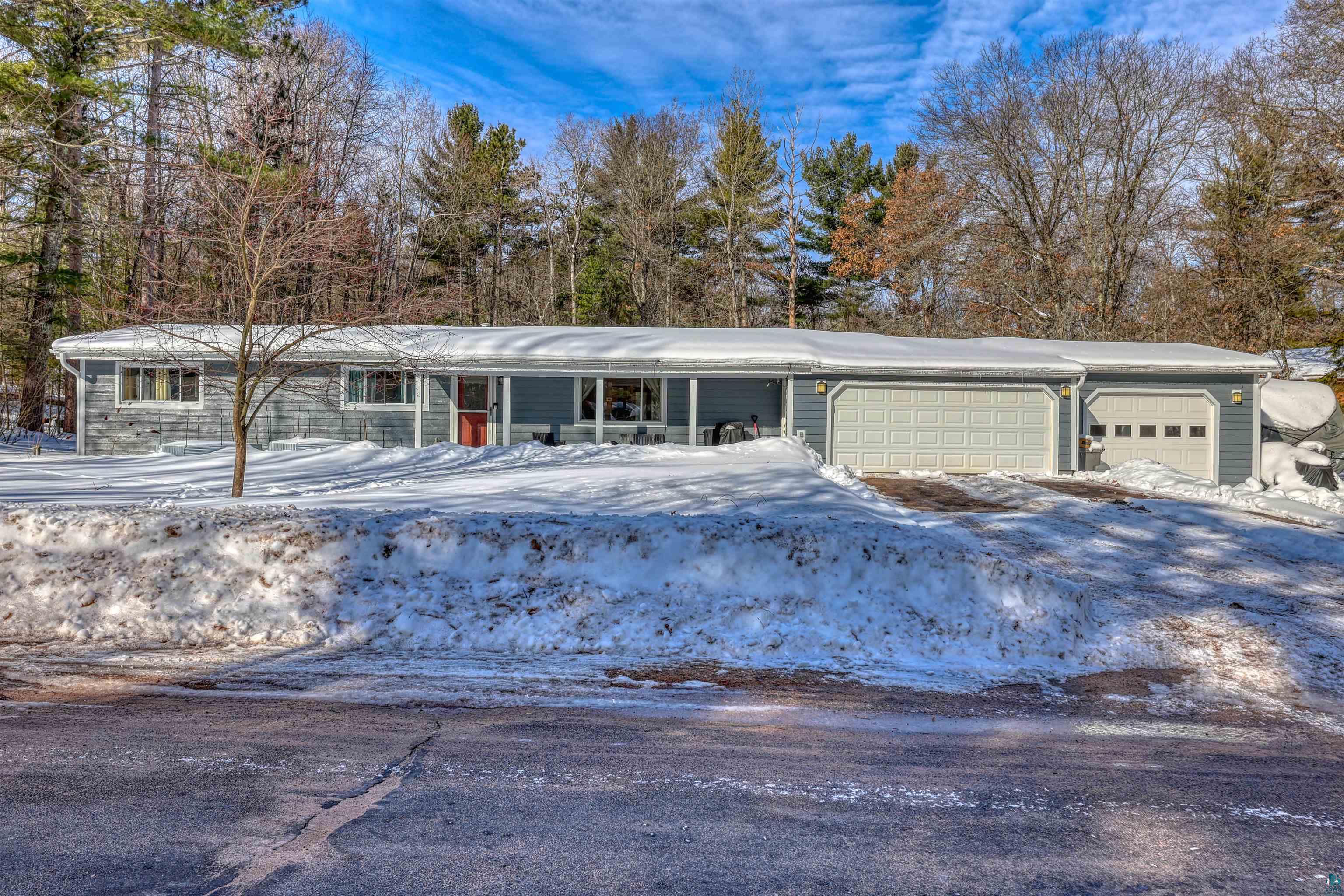 Ranch-style house with a garage, driveway, and a porch