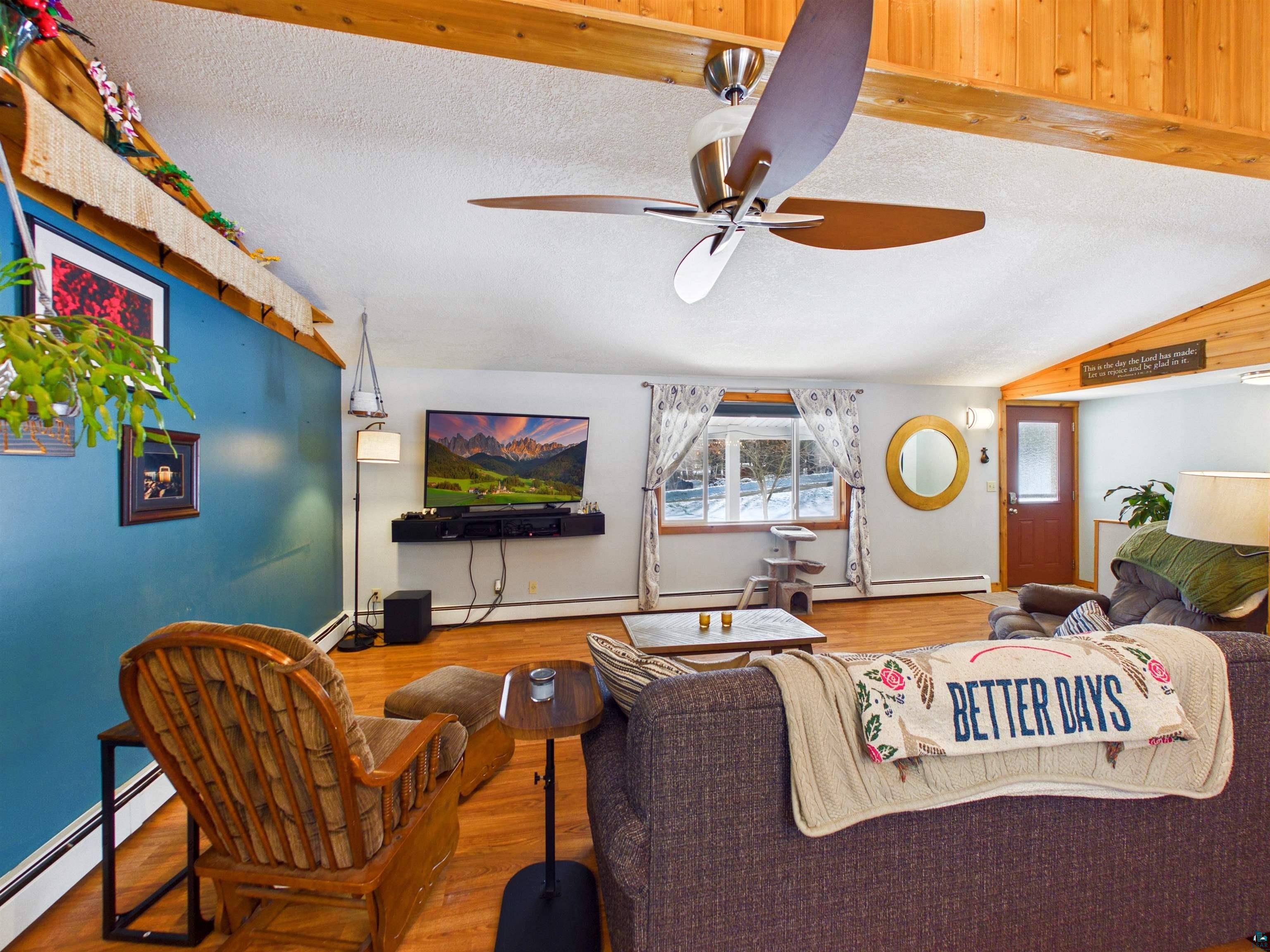 10719 North Oak Ridge Street Hayward, WI 54843 - Photo 14 of 57 Living area featuring wood finished floors, a textured ceiling, baseboard heating, and ceiling fan