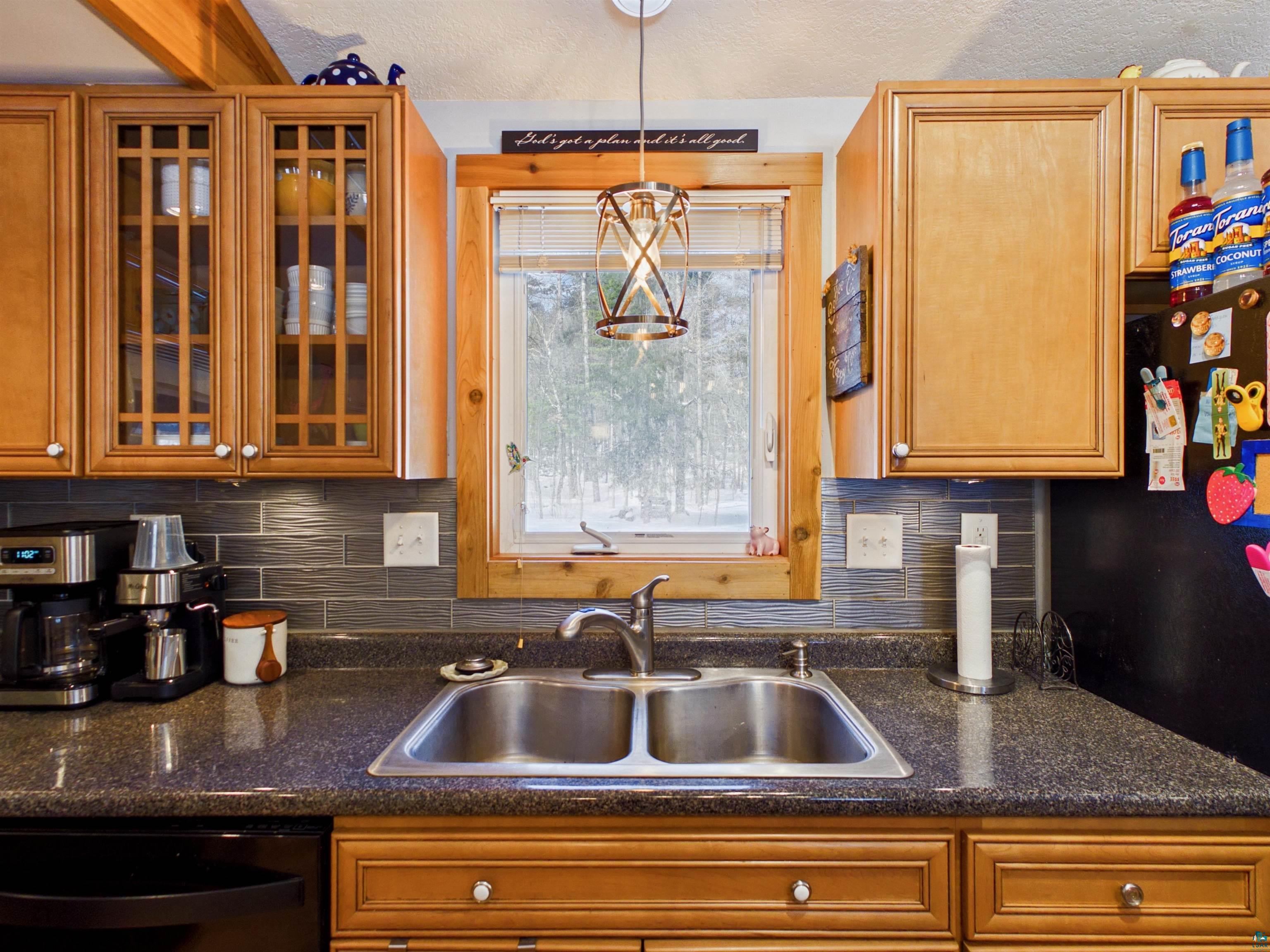 10719 North Oak Ridge Street Hayward, WI 54843 - Photo 21 of 57 Kitchen featuring glass fronted cabinets, freestanding refrigerator, dishwasher, and pendant lighting