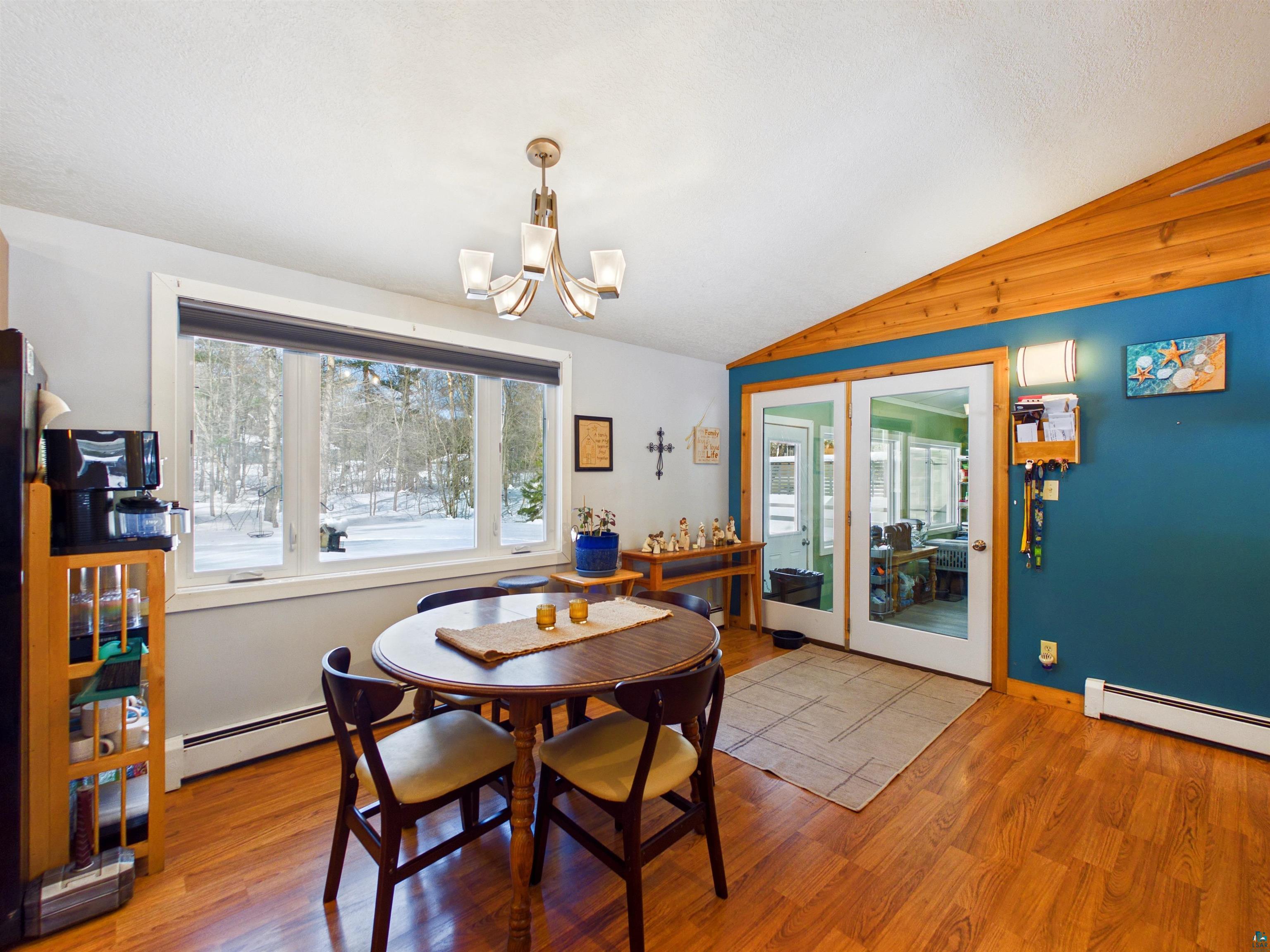 10719 North Oak Ridge Street Hayward, WI 54843 - Photo 26 of 57 Dining room featuring light wood-type flooring, plenty of natural light, vaulted ceiling, suspended lighting, and a baseboard radiator