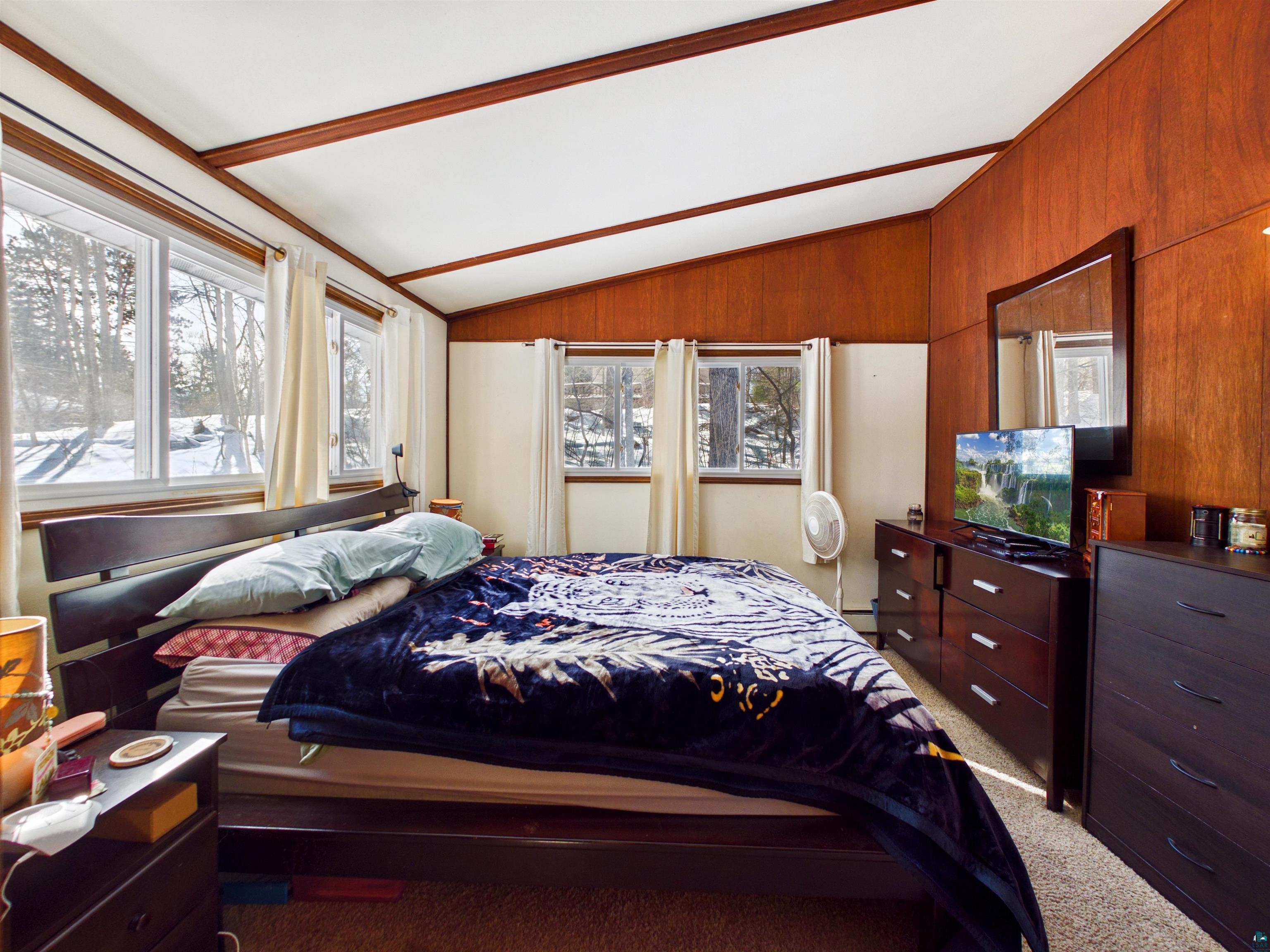 10719 North Oak Ridge Street Hayward, WI 54843 - Photo 30 of 57 Bedroom with vaulted ceiling, multiple windows, and light colored carpet