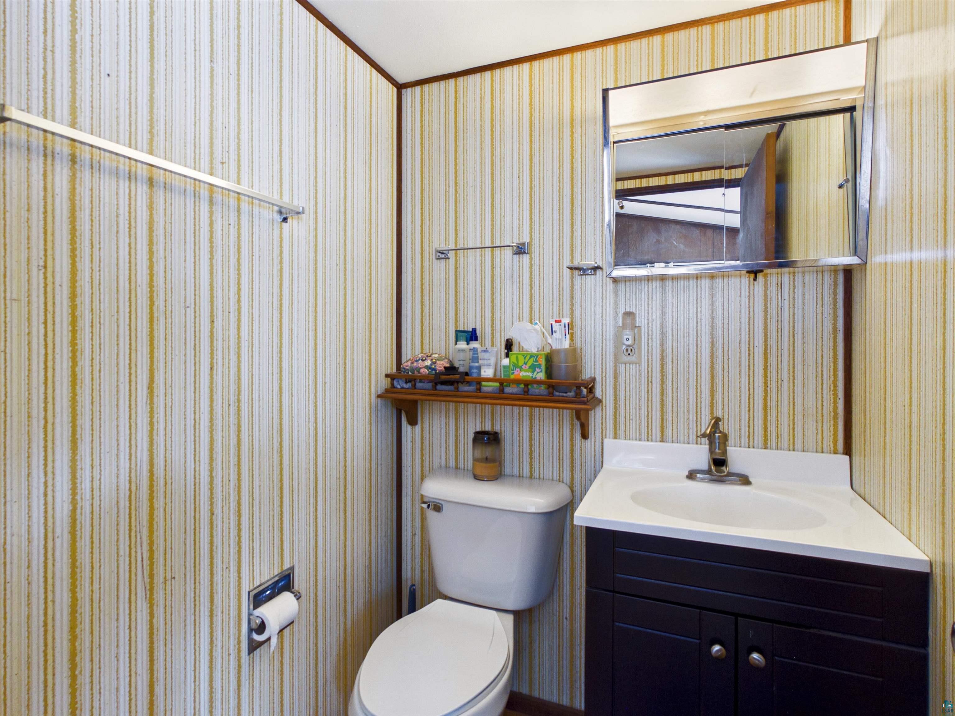 10719 North Oak Ridge Street Hayward, WI 54843 - Photo 31 of 57 Bathroom with vanity, wallpapered walls, and crown molding